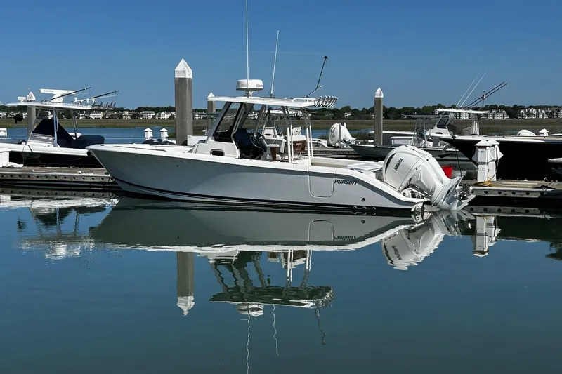 Slide: The Image of 2024 Pursuit S 288 Sport boat docked in a serene marina setting. - 13