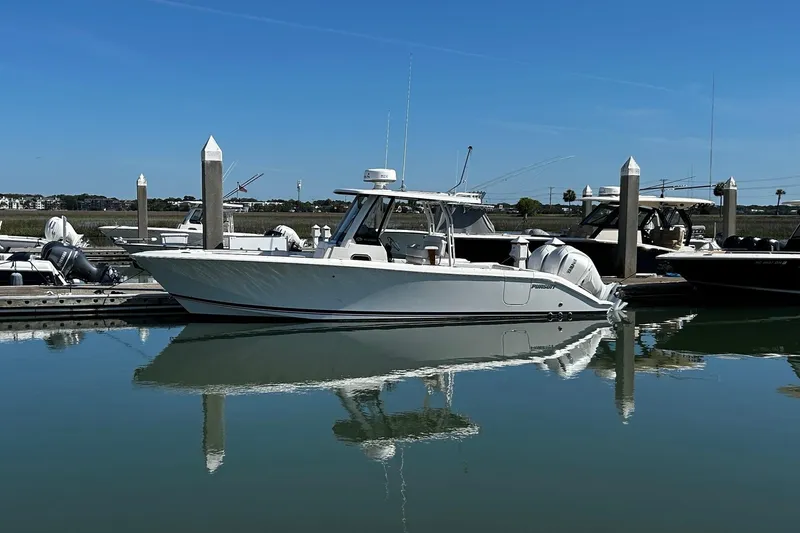 Slide: The Image of 2024 Pursuit S 288 Sport boat docked in a serene marina setting. - 14