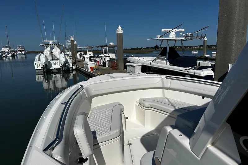 Slide: The Image of 2024 Pursuit S 288 Sport boat docked at marina under clear blue sky. - 3