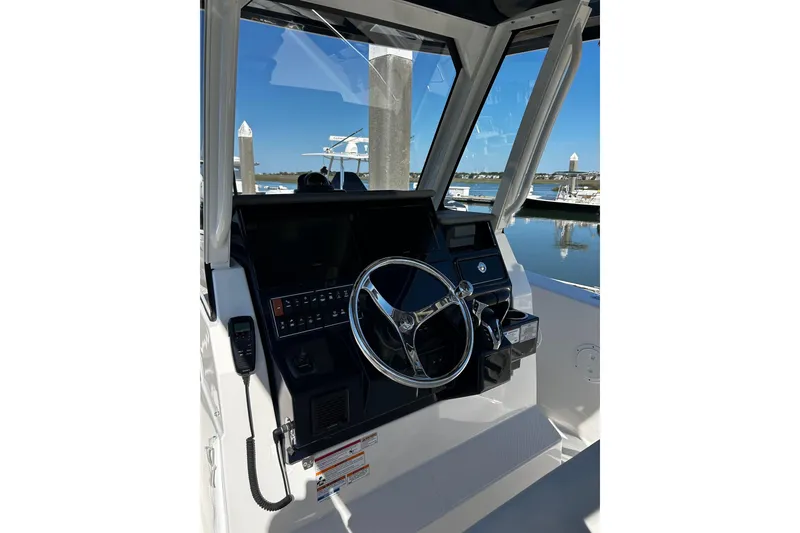 Slide: The Image of 2024 Pursuit S 288 Sport boat helm with steering wheel and control panel. - 5