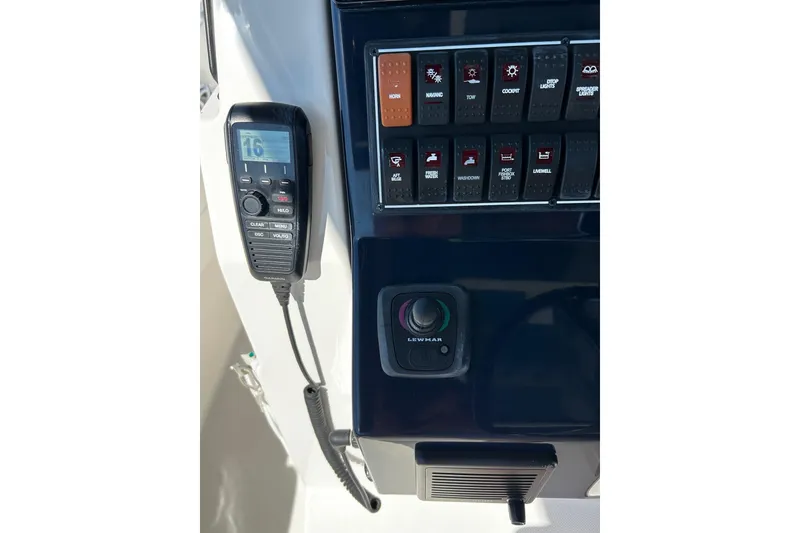 Slide: The Image of Control panel of 2024 Pursuit S 288 Sport boat with radio and switches. - 6