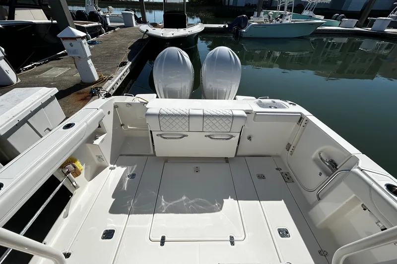 Slide: The Image of 2024 Pursuit S 288 Sport boat interior with dual engines at a marina dock. - 9