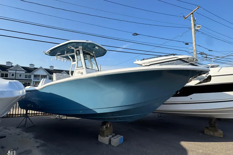 The Image of 2026 Tidewater 232 LXF boat in blue, displayed outdoors on a sunny day. - 1