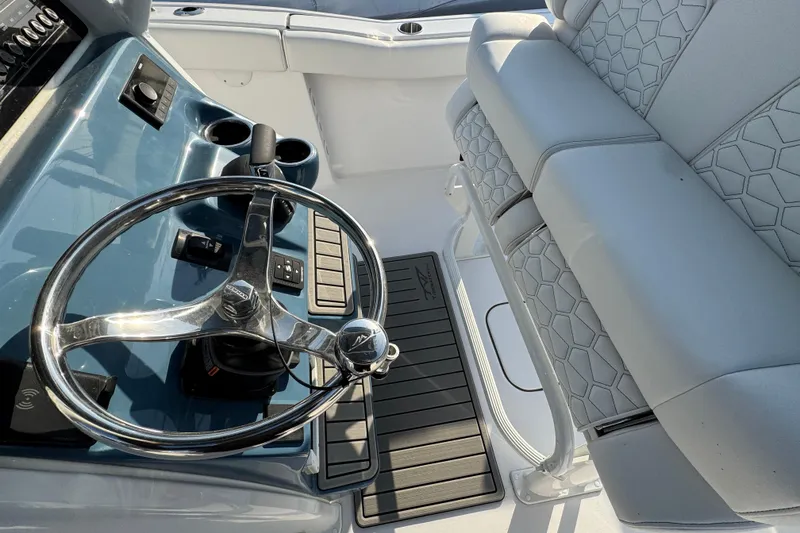 Slide: The Image of 2026 Tidewater 232 LXF boat interior with steering wheel and cushioned seating. - 11