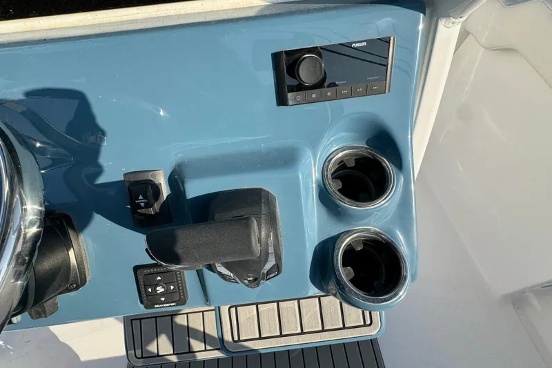Slide: The Image of Control panel of 2026 Tidewater 232 LXF boat with cup holders and audio system. - 14