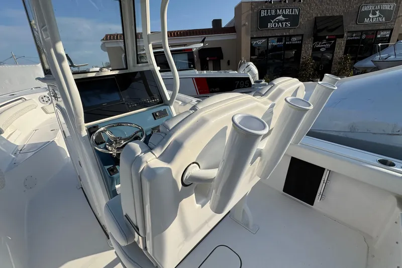 Slide: The Image of 2026 Tidewater 232 LXF boat interior with steering wheel and rod holders. - 6
