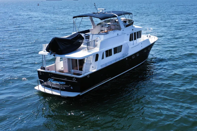 Slide: The Image of 2003 Jefferson Pilothouse 57 yacht cruising on open water, featuring a sleek design and spacious deck. - 5