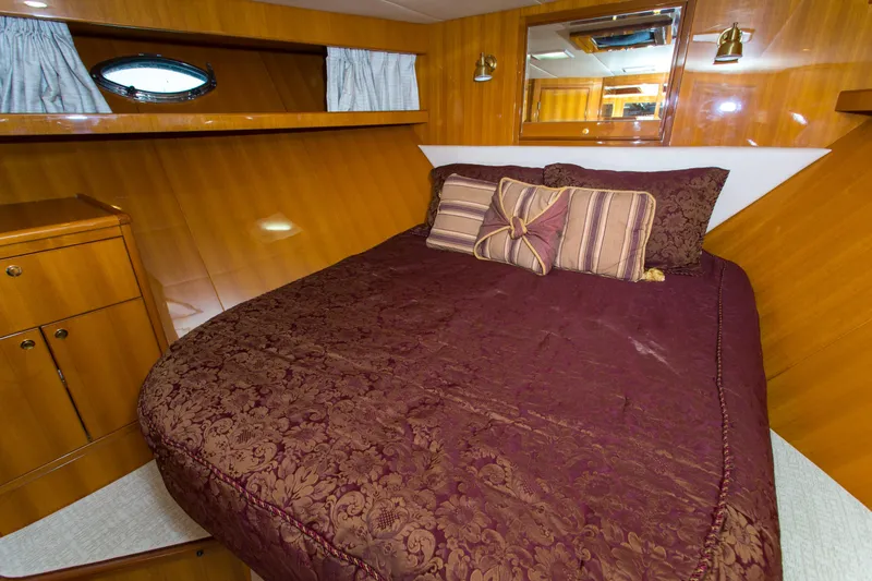 Slide: The Image of Luxurious cabin interior of 2003 Jefferson Pilothouse 57 yacht with elegant bedding and wood paneling. - 68