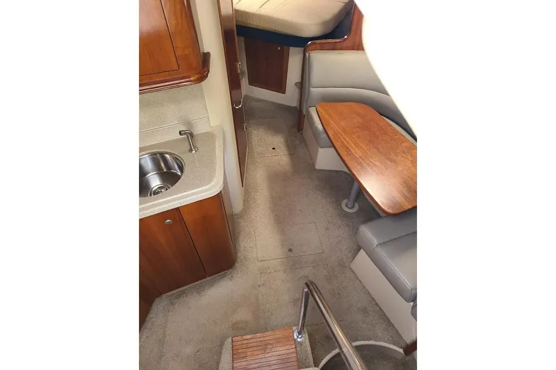 Slide: The Image of Interior of 2006 Cruisers Yachts 3470 Express, featuring kitchenette and seating area. - 14