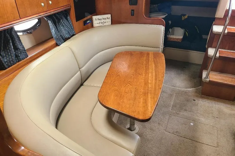 Slide: The Image of 2006 Cruisers Yachts 3470 Express interior with curved seating and wooden table. - 16