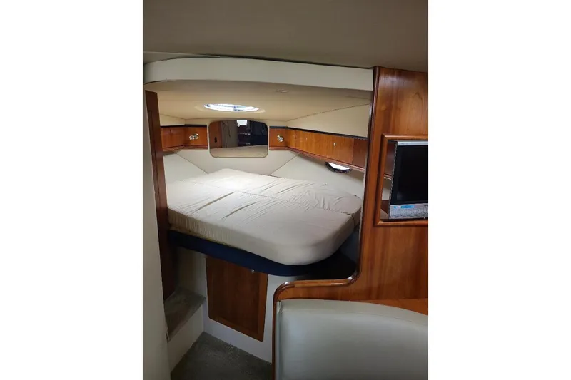 Slide: The Image of 2006 Cruisers Yachts 3470 Express cabin interior with bed and wooden accents. - 17