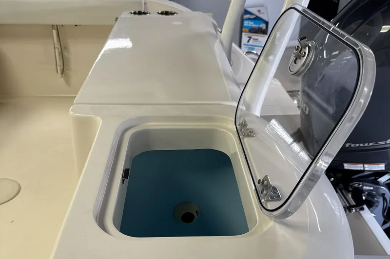 Slide: The Image of 2024 Cobia 220 Dual Console boat with open storage compartment. - 15