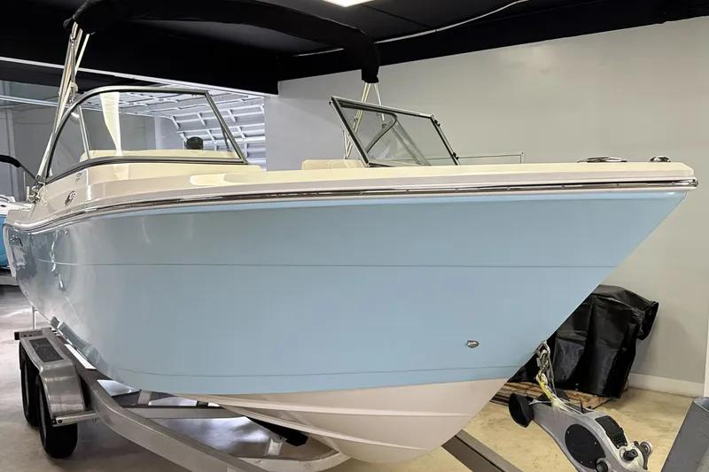 Slide: The Image of 2024 Cobia 220 Dual Console boat in a showroom. - 3