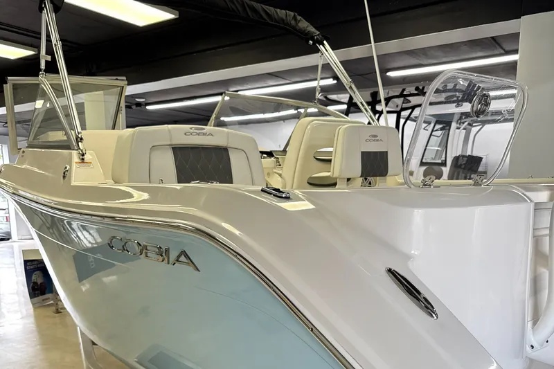 Slide: The Image of 2024 Cobia 220 Dual Console boat in showroom. - 7