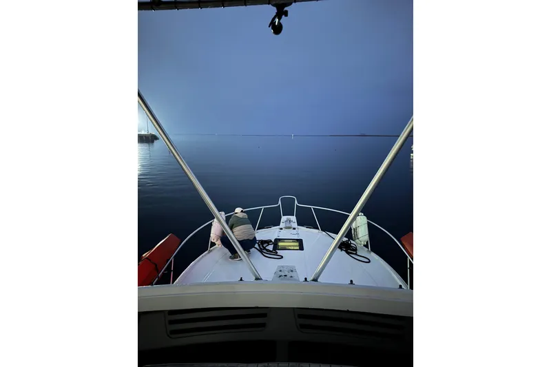 Slide: The Image of 1998 Luhrs Tournament 320 Convertible boat on calm water at dusk. - 11