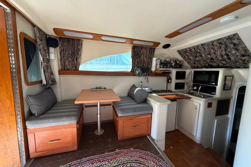 Slide: The Image of Interior of 1998 Luhrs Tournament 320 Convertible boat with cozy dining and kitchen area. - 18