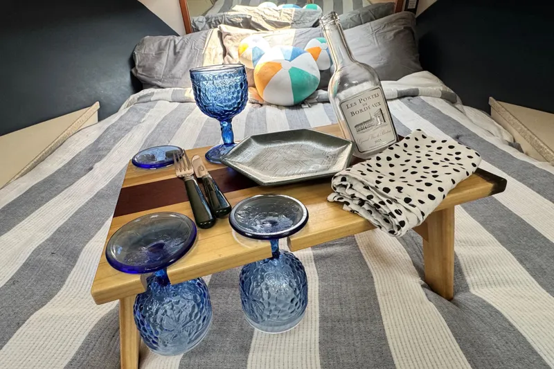 Slide: The Image of Cozy dining setup on Luhrs Tournament 320 Convertible, 1998, with blue glassware and wine bottle. - 24