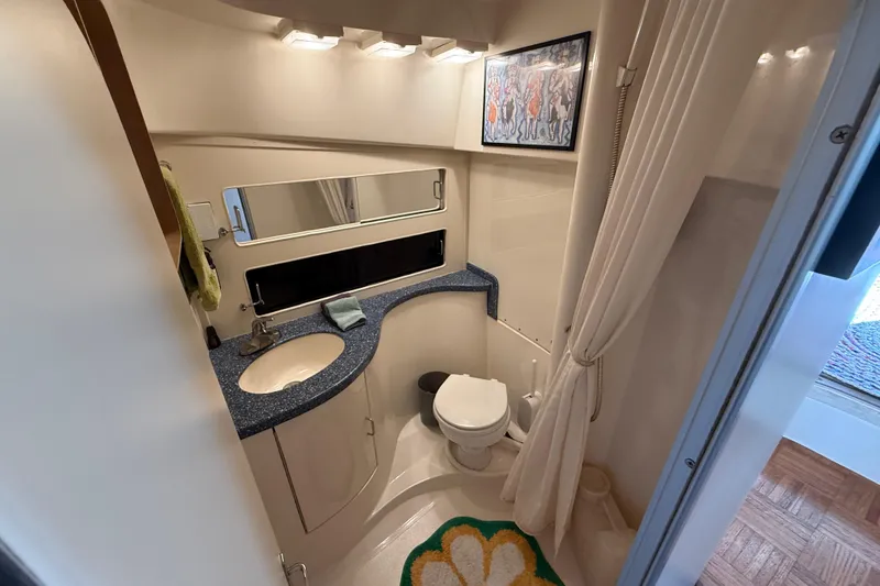 Slide: The Image of Bathroom interior of 1998 Luhrs Tournament 320 Convertible yacht, featuring sink, toilet, and mirror. - 25