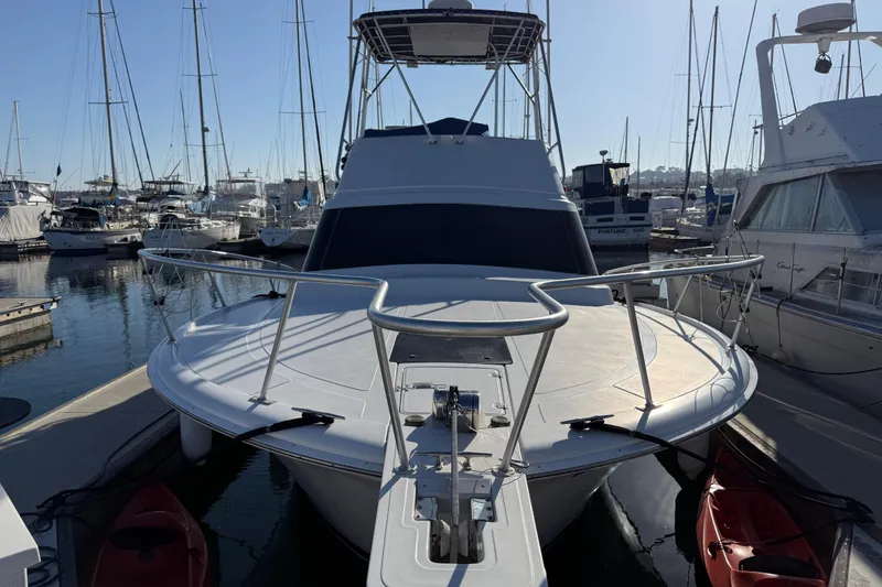 Slide: The Image of 1998 Luhrs Tournament 320 Convertible yacht docked in a marina, surrounded by other boats. - 4