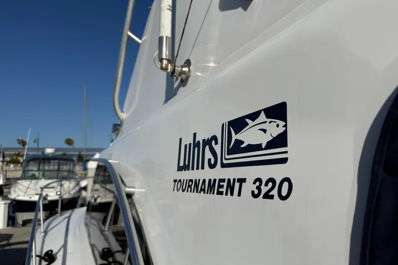 Slide: The Image of 1998 Luhrs Tournament 320 Convertible boat docked, showcasing logo and sleek design. - 8