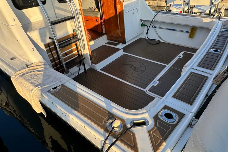 Slide: The Image of 1998 Luhrs Tournament 320 Convertible boat deck with ladder and wooden flooring. - 9