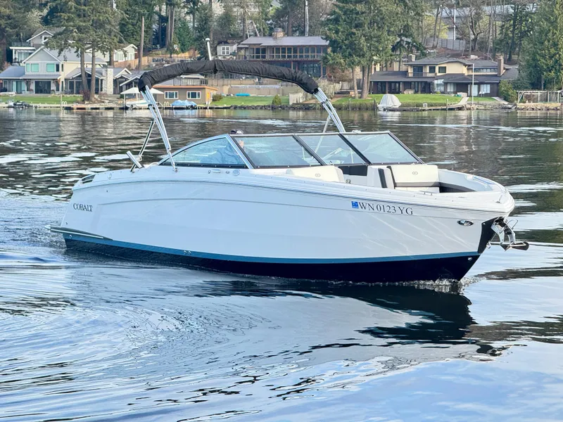 Slide: The Image of 2023 Cobalt R8 boat cruising on a serene lake with waterfront homes in the background. - 10