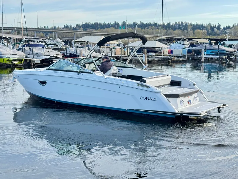 Slide: The Image of 2023 Cobalt R8 boat cruising in a marina, surrounded by other docked boats. - 15