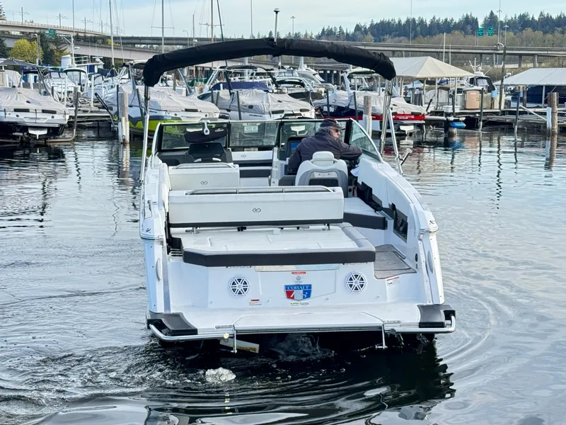 Slide: The Image of 2023 Cobalt R8 boat navigating marina waters, surrounded by docked boats. - 17