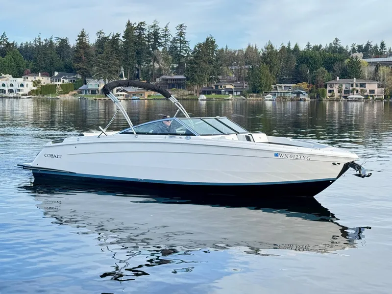 Slide: The Image of 2023 Cobalt R8 boat on a serene lake with forested shoreline. - 23