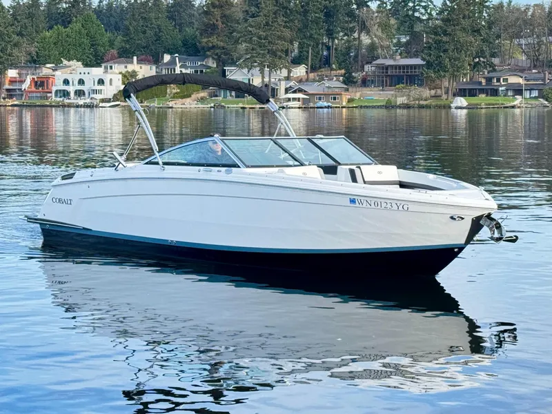 Slide: The Image of 2023 Cobalt R8 boat on a serene lake with waterfront homes in the background. - 25