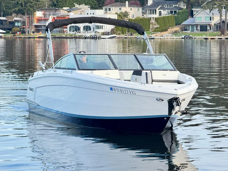 Slide: The Image of 2023 Cobalt R8 boat cruising on a calm lake near waterfront homes. - 26