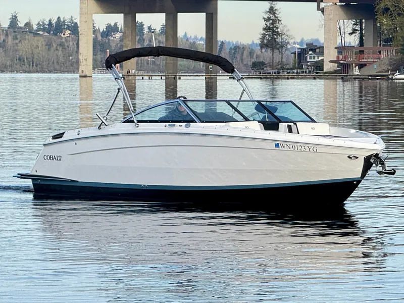 Slide: The Image of 2023 Cobalt R8 boat on calm water near a bridge, scenic background. - 27