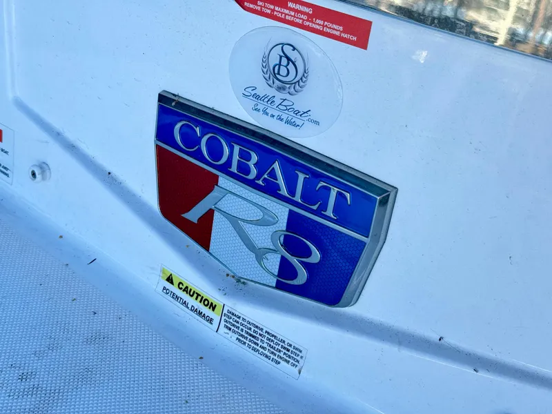 Slide: The Image of Cobalt R8 2023 model emblem on a white boat surface with caution labels. - 28