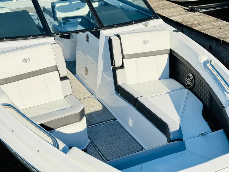 Slide: The Image of 2023 Cobalt R8 boat interior with white and gray seating, docked by wooden pier. - 34