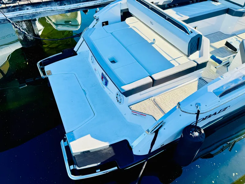 Slide: The Image of 2023 Cobalt R8 boat with spacious deck and seating, docked on calm water. - 36