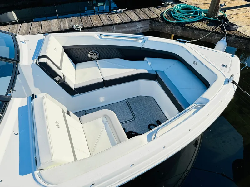 Slide: The Image of 2023 Cobalt R8 boat interior with white seating and sleek design at a dock. - 4