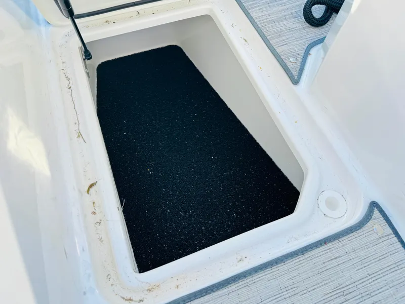 Slide: The Image of Storage compartment in 2023 Cobalt R8 boat, featuring a black non-slip surface. - 44