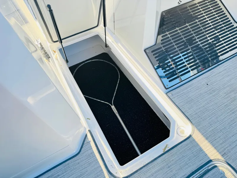 Slide: The Image of Open storage compartment on 2023 Cobalt R8 boat with net inside. - 45