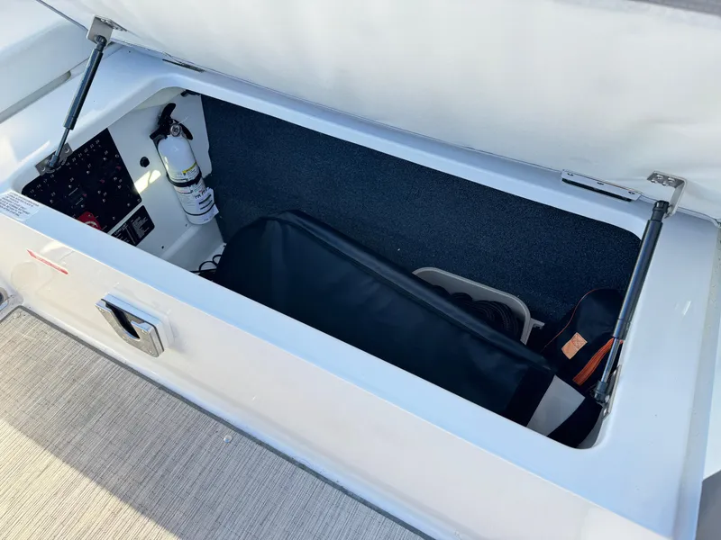 Slide: The Image of Storage compartment in 2023 Cobalt R8 boat, featuring organized interior and safety equipment. - 47
