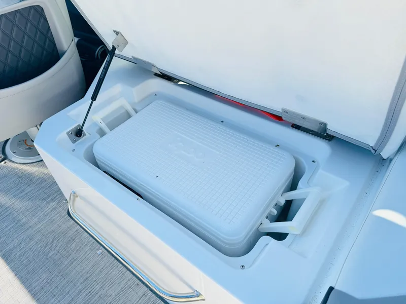 Slide: The Image of 2023 Cobalt R8 boat cooler compartment with open lid, showcasing interior storage. - 48