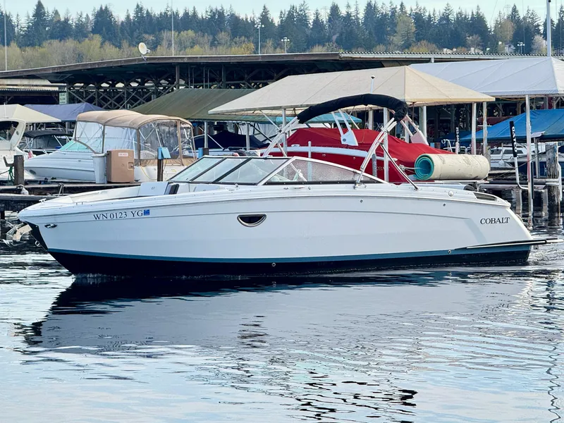 Slide: The Image of 2023 Cobalt R8 boat docked at marina with covered slips in background. - 9