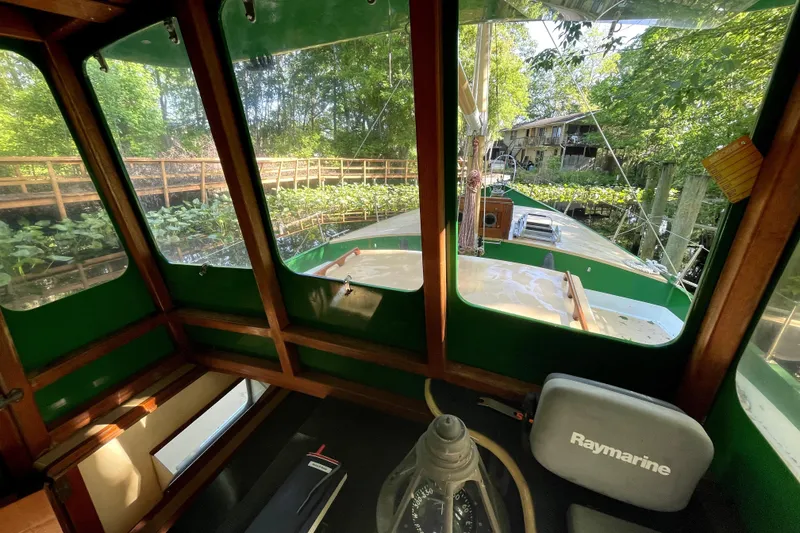 Slide: The Image of Interior view of 1995 Rover Marine Lines Bonny Rover boat with lush greenery outside. - 11