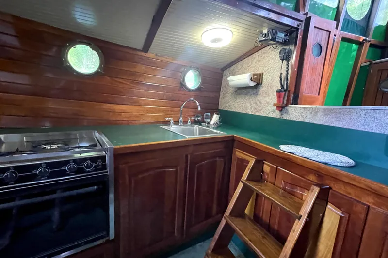 Slide: The Image of Cozy 1995 Bonny Rover boat kitchen with wooden cabinetry and modern appliances. - 20