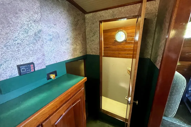 Slide: The Image of Interior of 1995 Rover Marine Lines Bonny Rover boat with wooden cabinetry and porthole. - 25