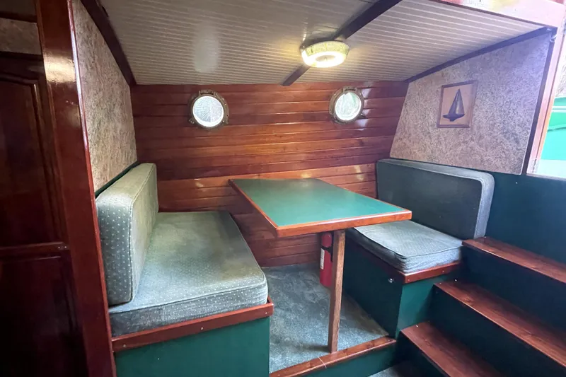 Slide: The Image of Cozy 1995 Rover Marine Lines Bonny Rover cabin with wooden interior and seating area. - 26