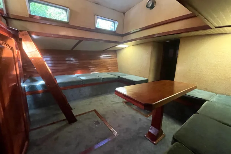 Slide: The Image of Interior of 1995 Rover Marine Lines Bonny Rover boat with wooden table and cushioned seating. - 28