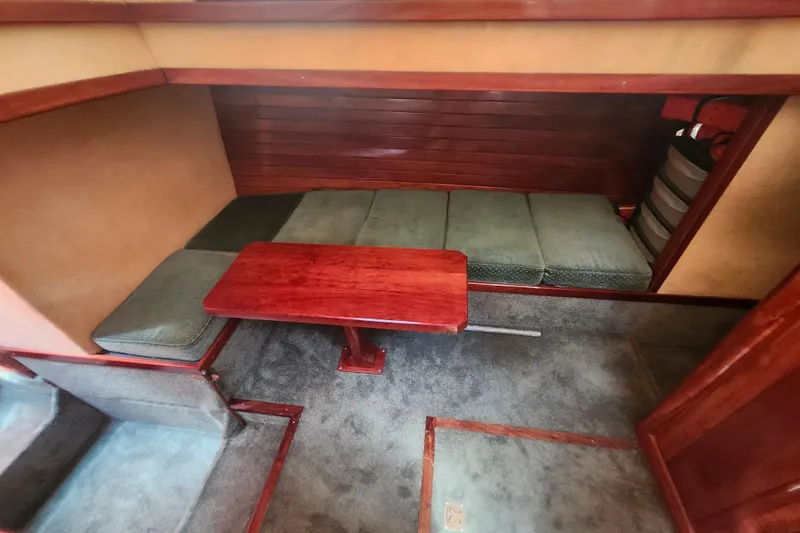 Slide: The Image of Interior of 1995 Rover Marine Lines Bonny Rover with cushioned seating and wooden table. - 29