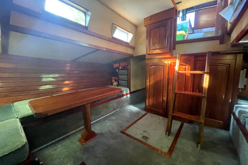 Slide: The Image of Interior of 1995 Rover Marine Lines Bonny Rover boat with wooden furnishings and seating area. - 31