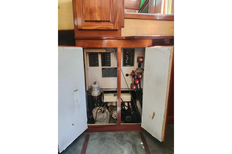 Slide: The Image of Electrical panel inside a 1995 Rover Marine Lines Bonny Rover boat, with open wooden cabinet doors. - 52