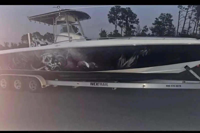 The Image of 2003 Sports Fisher 340 boat on trailer with artistic side graphics, parked outdoors. - 1